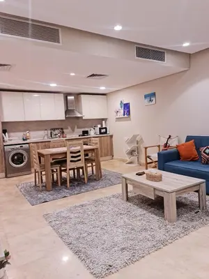 a living room with a table and a blue couch at 1 bedroom in mangroovy El gouna in Hurghada