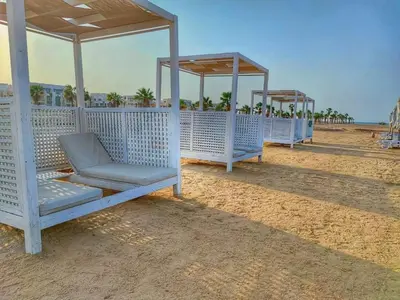 a row of white benches on the beach at 1 bedroom in mangroovy El gouna in Hurghada