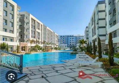 a swimming pool in front of some apartment buildings at Fanadir bay resort in Hurghada