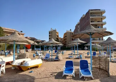 a sandy beach with chairs and umbrellas and chairs at Fiesta Beach Resort in Hurghada