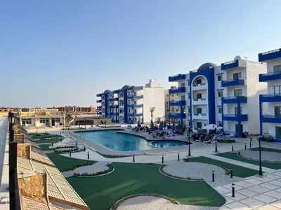 a resort with a swimming pool and some buildings at شقة فندقية صف أول بحر وبول in Hurghada