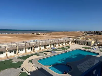 a view of a resort with a swimming pool and the beach at شقة فندقية صف أول بحر وبول in Hurghada