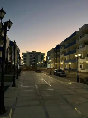 a street with a parking lot with a hotel at شقة فندقية صف أول بحر وبول in Hurghada