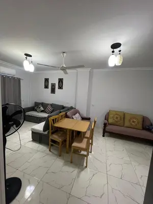 a living room with a table and a couch at شقة فندقية صف أول بحر وبول in Hurghada