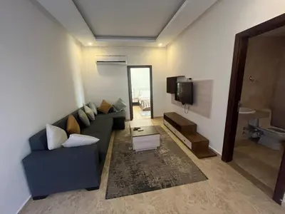 a living room with a blue couch and a tv at Mirage Bay Apartments in Hurghada