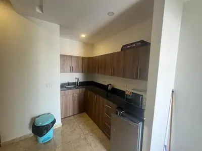 a small kitchen with wooden cabinets and a sink at Mirage Bay Apartments in Hurghada
