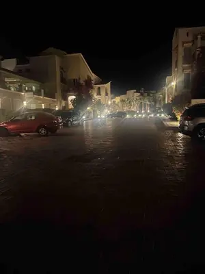 a street at night with cars parked in a parking lot at Luxurious Cozy studio in Sahl Hasheesh Hurghada in Hurghada