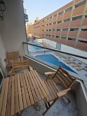 two chairs and a swimming pool on top of a building at Nada C206 in Hurghada