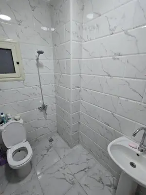 a white bathroom with a toilet and a sink at Nada C206 in Hurghada