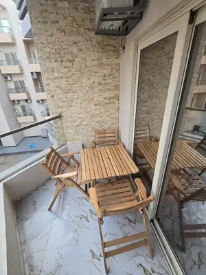 a wooden table and chairs on a balcony at Nada C206 in Hurghada
