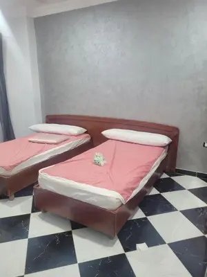 two twin beds in a room with a checkered floor at Hurghada down town in Hurghada