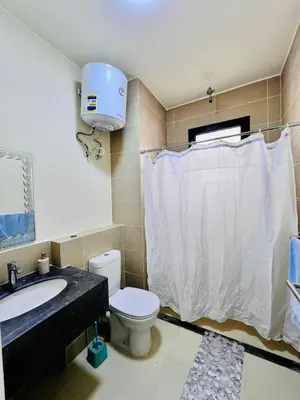 a bathroom with a white toilet and a sink at Sea View Serenity - Stylish 2BR Retreat in Hurghada