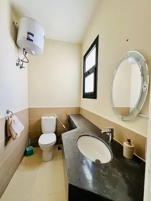 a bathroom with a sink and a toilet and a mirror at Sea View Serenity - Stylish 2BR Retreat in Hurghada