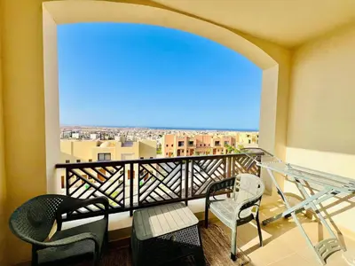 a balcony with chairs and a view of a city at Sea View Serenity - Stylish 2BR Retreat in Hurghada