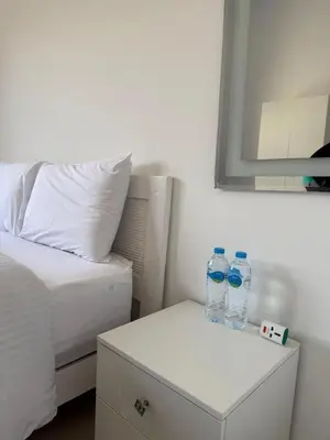 two bottles of water sitting on a nightstand next to a bed at Cozy 2BR with pool access in Hurghada