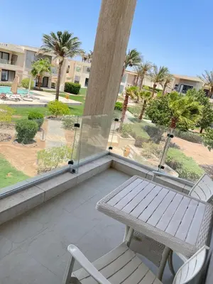 a porch with a bench and a table and chairs at Cozy 2BR with pool access in Hurghada