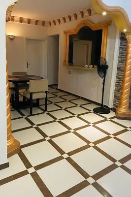 a room with a checkered floor with a table and a mirror at Casa De Amor in Abu Dabab