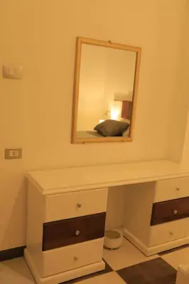 a mirror on top of a dresser with a bed at Casa De Amor in Abu Dabab