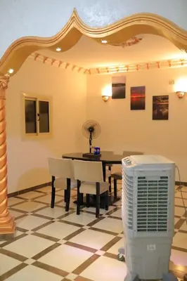 a dining room with a table and chairs and a fan at Casa De Amor in Abu Dabab