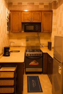 a kitchen with a stove and a microwave at Casa De Amor in Abu Dabab