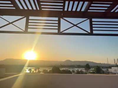 a view of the sunset from the roof of a building at Spacious Luxury Nile-View Apartment on Upper Floor with Rooftop, Jacuzzi & BBQ ,Steps from Hilton Hotel in Luxor