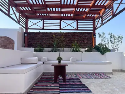 a living room with a couch and a table at Spacious Luxury Nile-View Apartment on Upper Floor with Rooftop, Jacuzzi & BBQ ,Steps from Hilton Hotel in Luxor