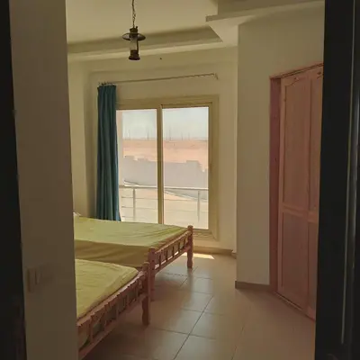 a bedroom with a bed and a large window at George Villa in Hurghada