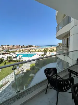 a balcony with chairs and a view of the beach at Scandic Beach Luxury in Hurghada
