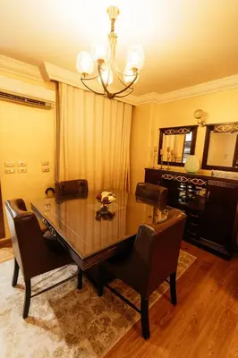 a dining room table with chairs and a chandelier at Aswan Heritage Residence-Nile View and Free Airport Pickup in Aswan
