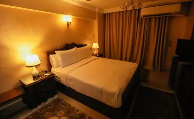 a hotel room with a bed and two lamps at Aswan Heritage Residence-Nile View and Free Airport Pickup in Aswan