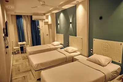 a room with three beds in a room at Town Hotel- Hurghada in Hurghada