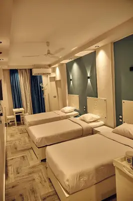 a hotel room with three beds in it at Town Hotel- Hurghada in Hurghada