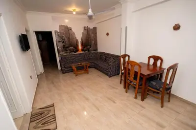 a living room with a table and a couch at White Flower Flats in Luxor