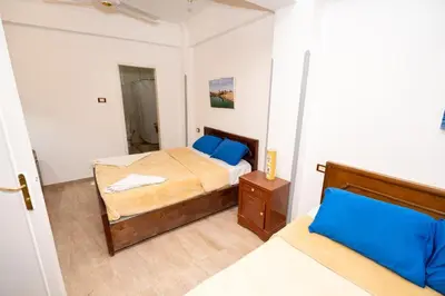 a small bedroom with a bed and a mirror at White Flower Flats in Luxor
