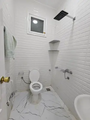 a white bathroom with a toilet and a sink at Hatschepsut hous in ‘Ezbet Abu Ḥabashi