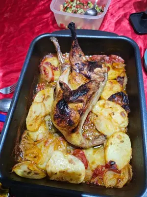 a pan of food with a chicken and potatoes at Hatschepsut hous in ‘Ezbet Abu Ḥabashi