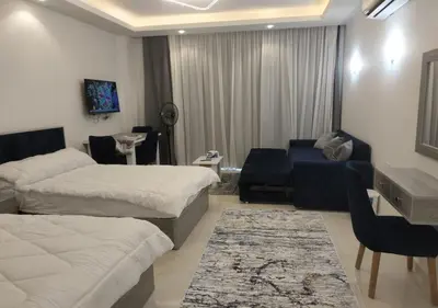 a bedroom with two beds and a couch and a desk at See view Studio-Hurghada Selena Bay Resort in Hurghada