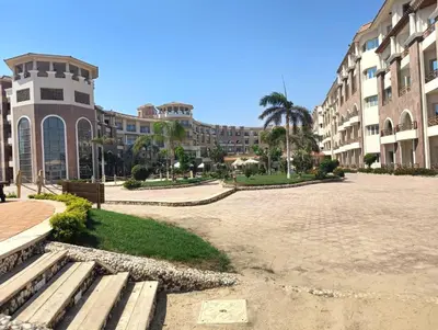 a park with benches in front of a building at Royal Beach Resort in Hurghada