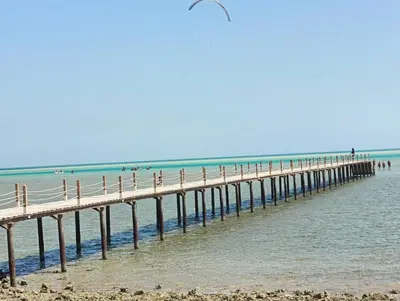 a pier stretches out over the water at the beach at Royal Beach Resort in Hurghada
