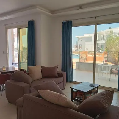 a living room with couches and a view of a patio at George Villa in Hurghada