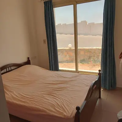 a bedroom with a bed and a large window at George Villa in Hurghada