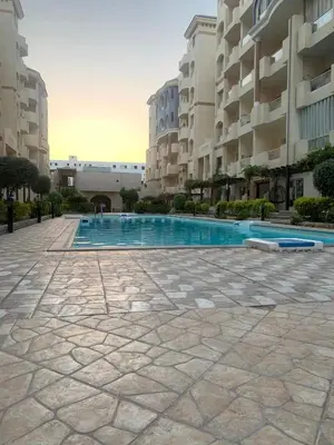 a swimming pool in a courtyard of a building at كمبوند فلورنزا خمسين عرابيا in Hurghada