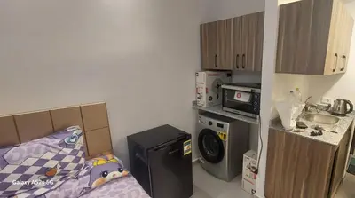 a small kitchen with a bed and a washing machine at كمبوند فلورنزا خمسين عرابيا in Hurghada