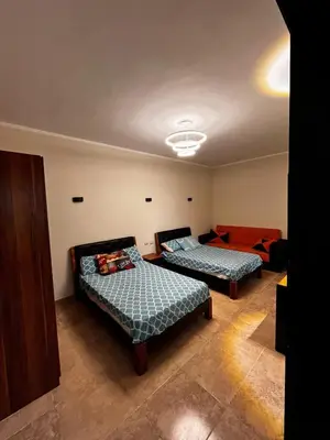 a bedroom with two beds and a couch at Florenza Khamsin GH in Hurghada