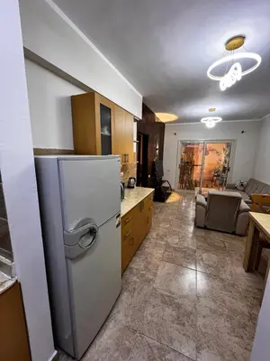 a kitchen with a refrigerator and a living room at Florenza Khamsin GH in Hurghada