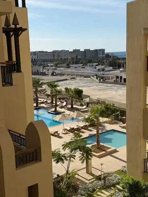 a view of a resort with a pool and palm trees at Aldau Heights Modern Serenity Studio in Hurghada