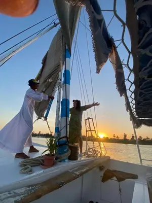 two people on a sail boat at sunset at Home of Natural in Luxor