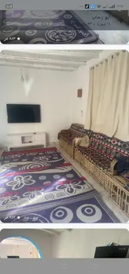a room with two beds and a tv in it at Home of Natural in Luxor