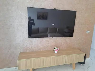 a living room with a tv on the wall at Amazing Apartment in Fanadir Hotel with Nice View F408 in Hurghada