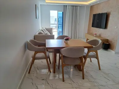 a living room with a wooden table and chairs at Amazing Apartment in Fanadir Hotel with Nice View F408 in Hurghada
